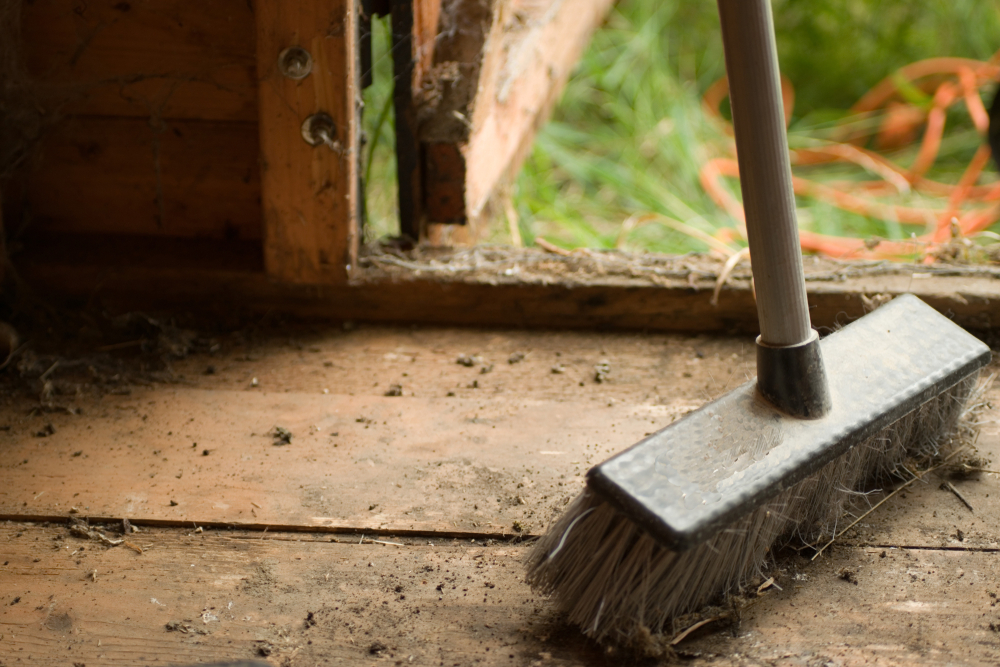 a wire broom stood in a shed doorway a wire broom stood in a shed doorway