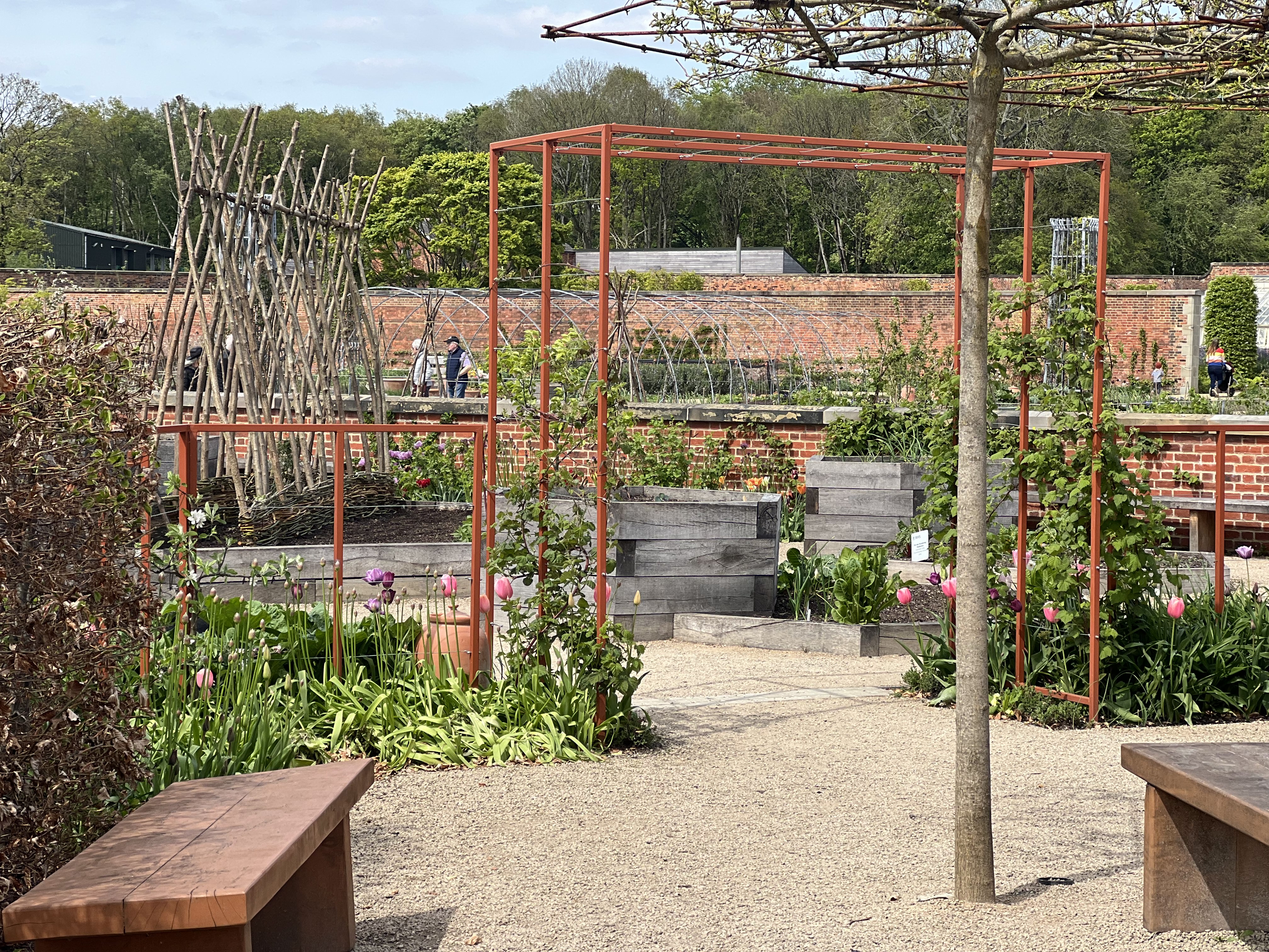 A red structure surrounded by trees and flowers