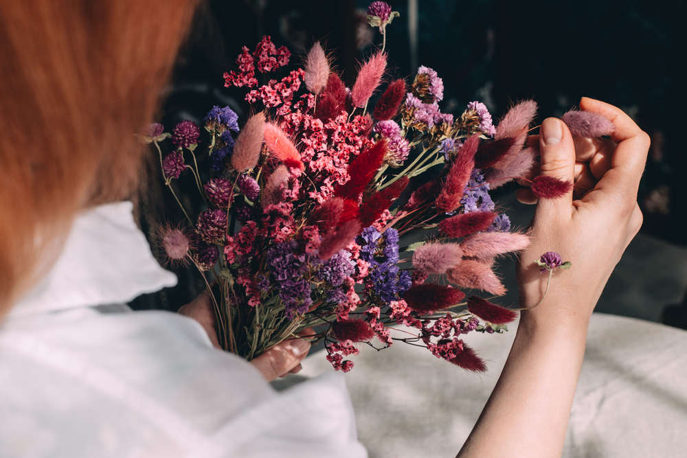woman holding a bouquet of red dried flowers