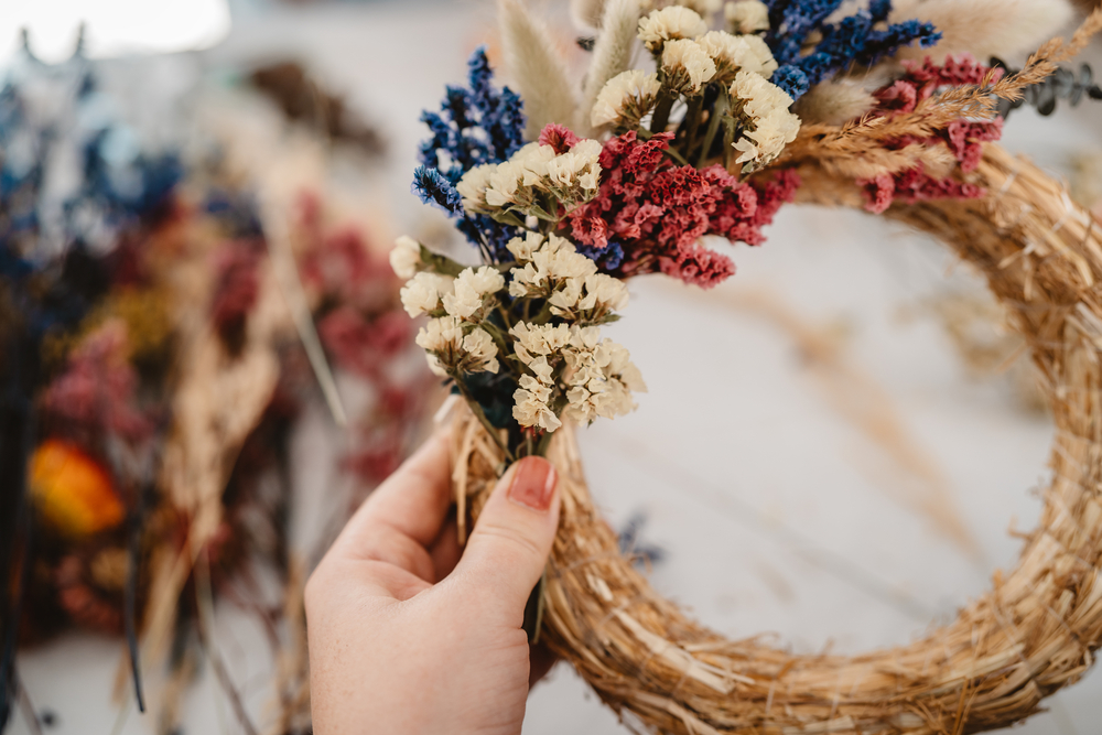 woman's hand holding a dried flower wreath