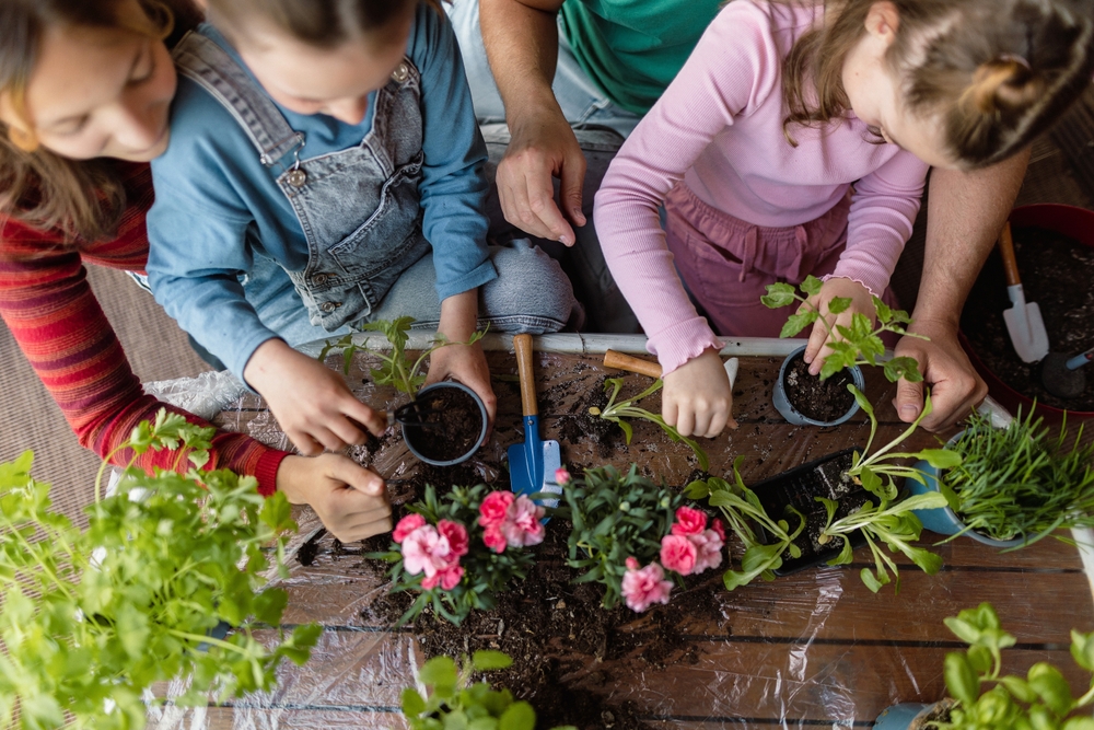 parents planting flowers with children