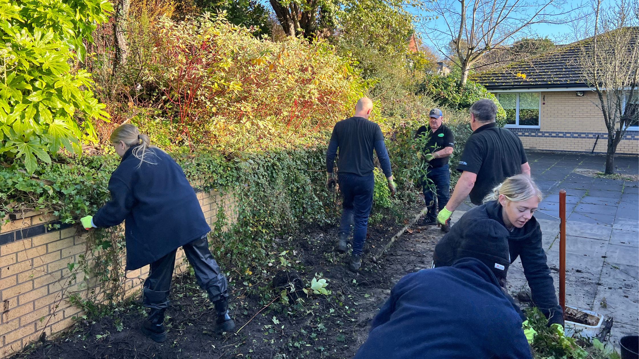 people in black uniforms digging a garden